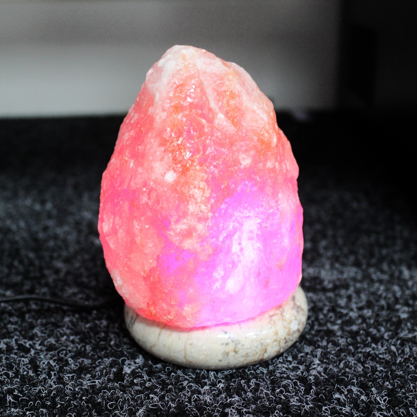 Himalayan Crystal Salt Lamp glowing softly, emitting a warm ambiance in a cozy room.