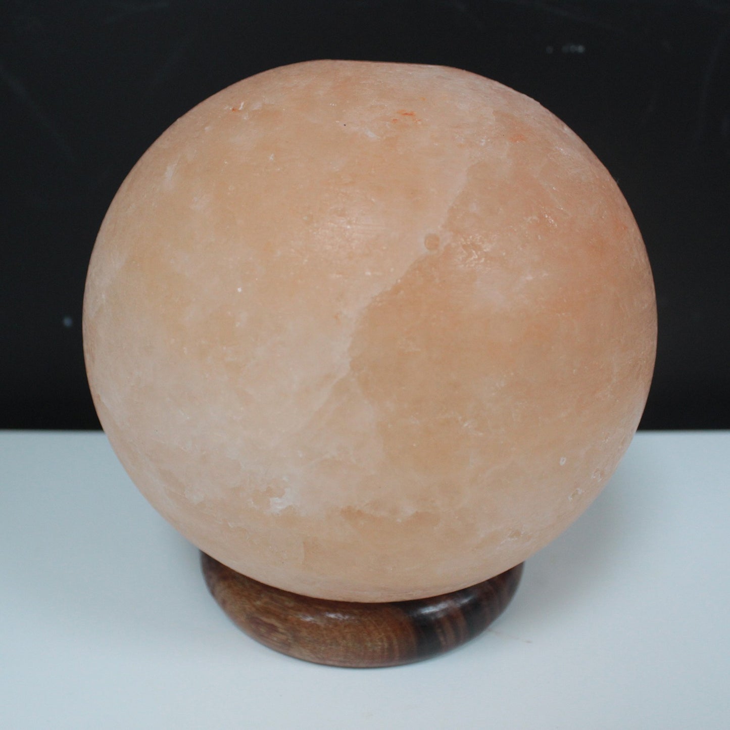 Image of salt lamp ball from slightly above , showing wooden base