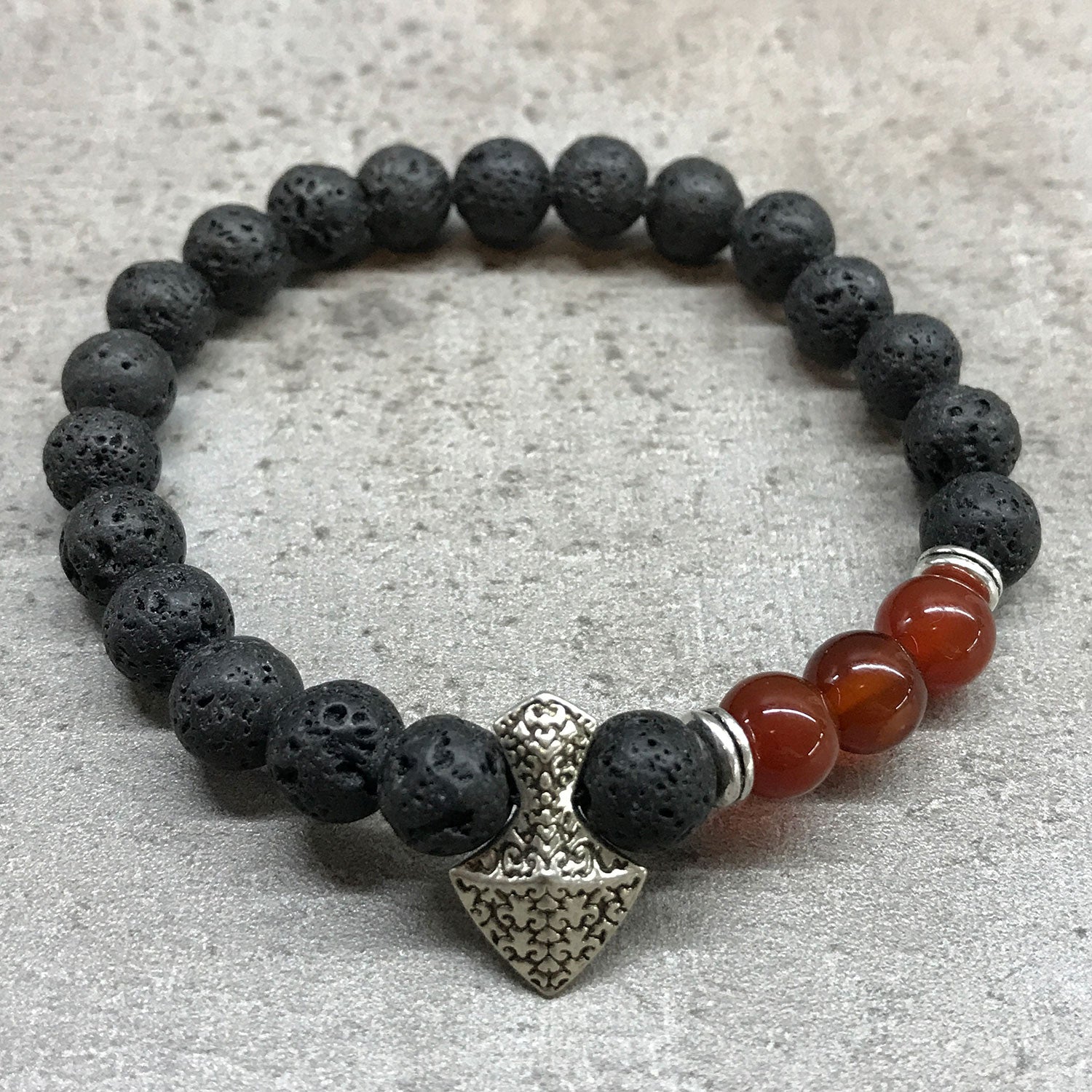 Lava stone bracelet with Axe-head Carnelian gemstones. Universal fit, perfect gift for aromatherapy enthusiasts. Shop now! on grey background