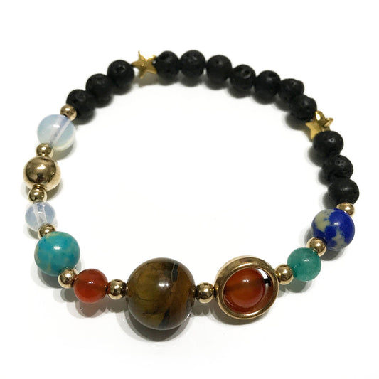 Unisex Lava Stone Bracelet - Gold Solar System on white surface. Aromatherapy lava bracelet with natural lava stones and solar system charms, one size fits all.