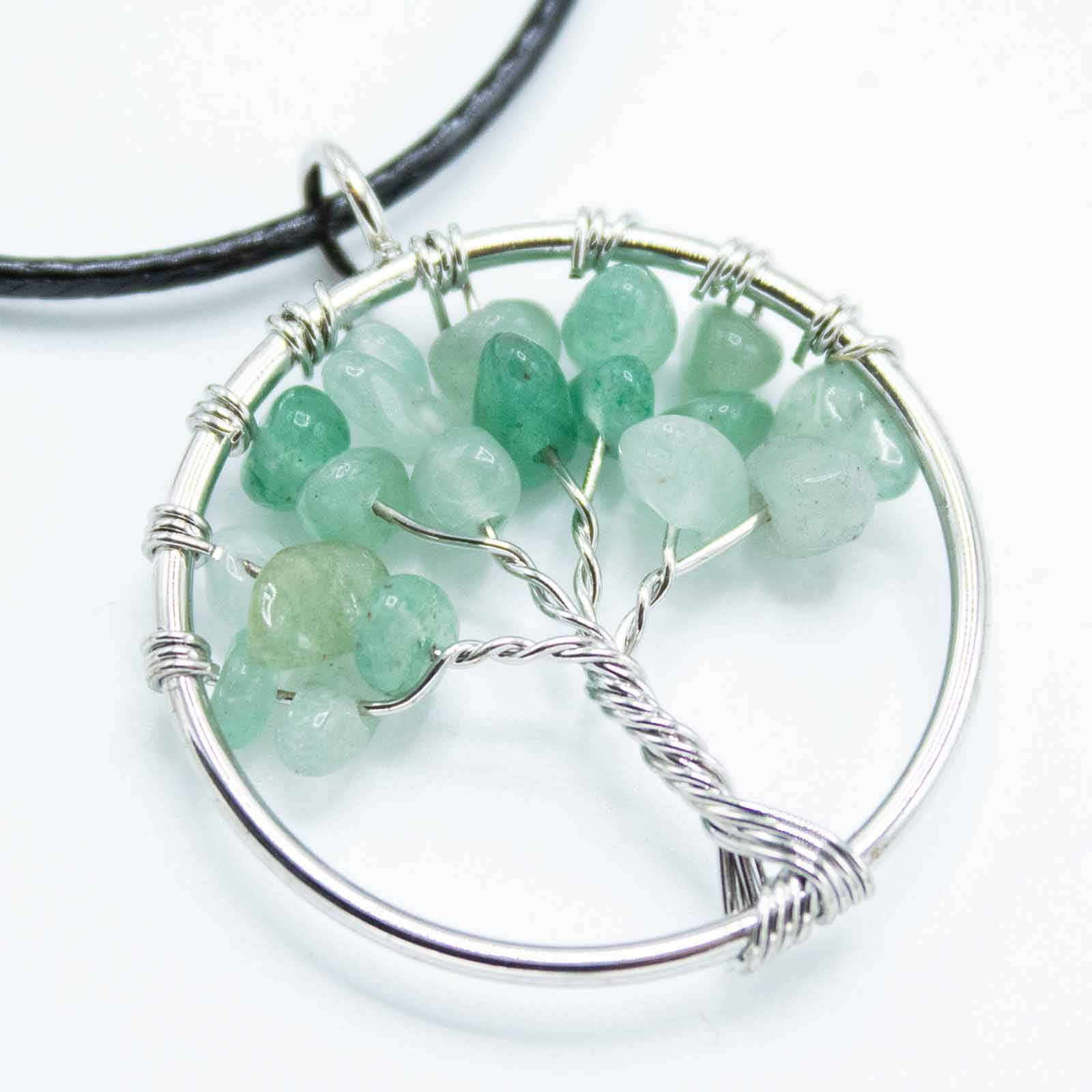 Image of a women's tree of life pendant featuring beautiful Jade gemstones, symbolizing elegance and sophistication. Front, very close up image