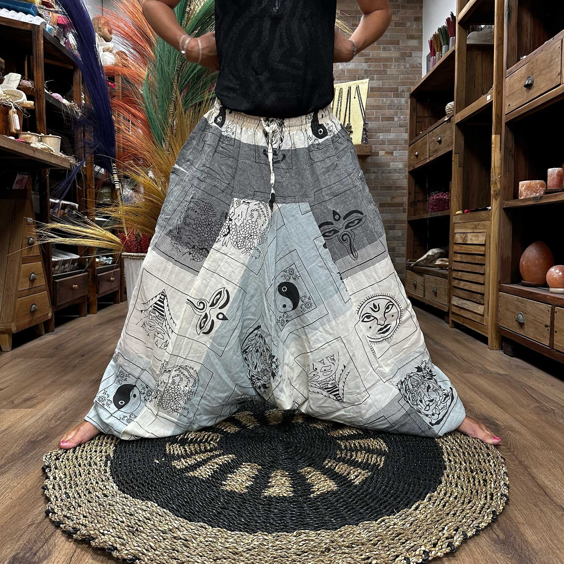 Someone standing in a wide stance wearing the Aladdin Yoga & Festival Pants, himalayan print on grey