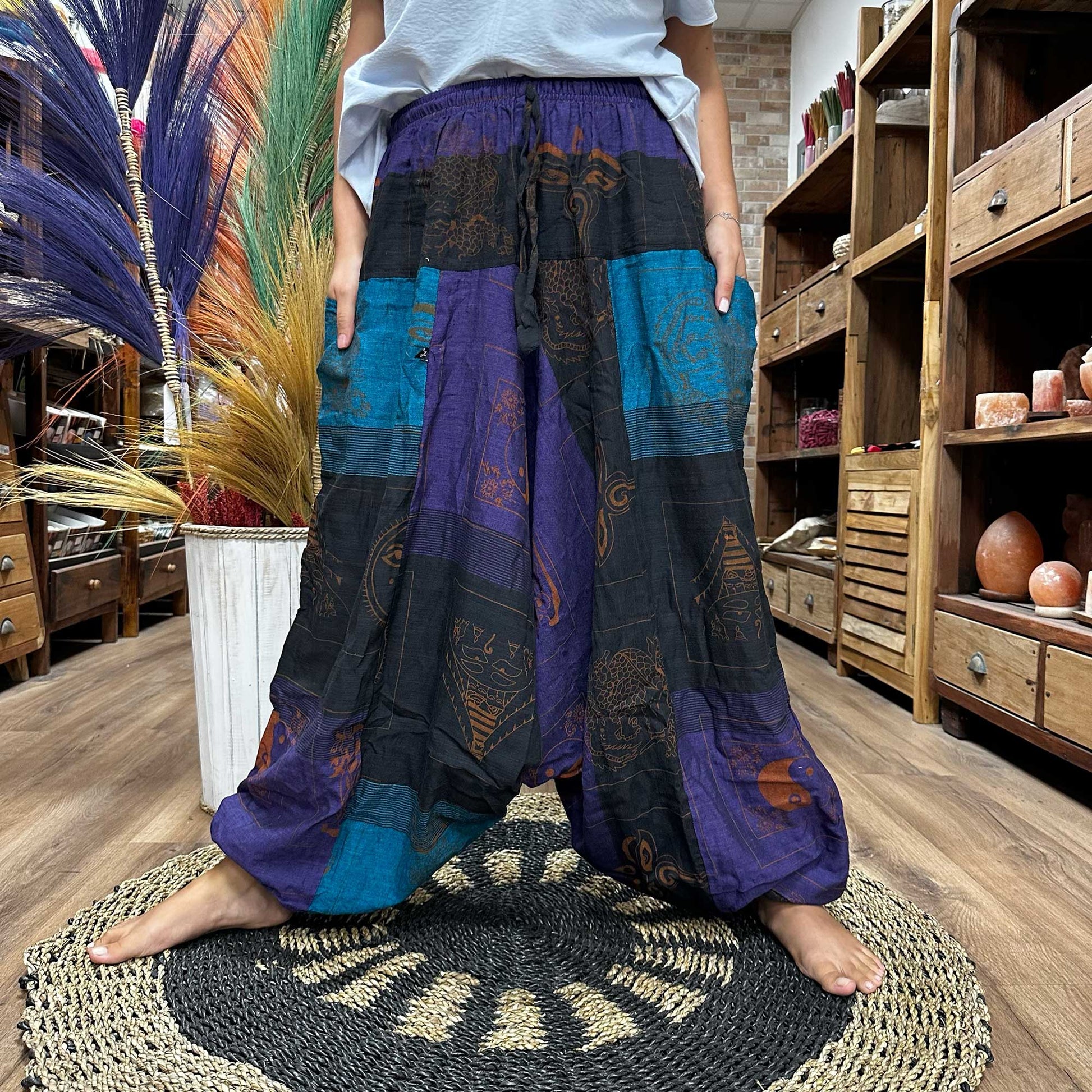 Someone standing in a wide stance wearing the Aladdin Yoga & Festival Pants, himalayan print on purple