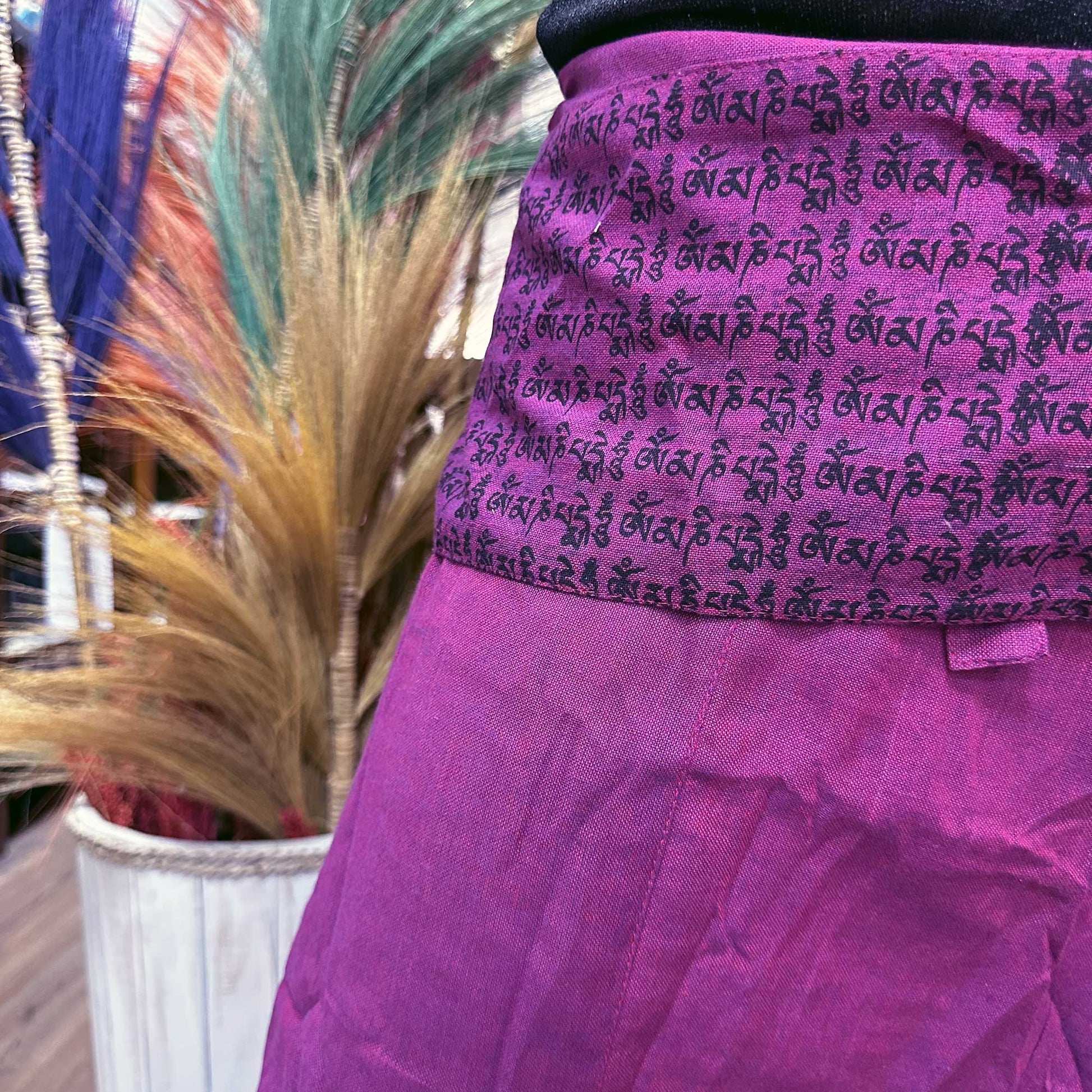 Close up of the top of unisex Thai Fisherman yoga pants, mandala mantra on purple