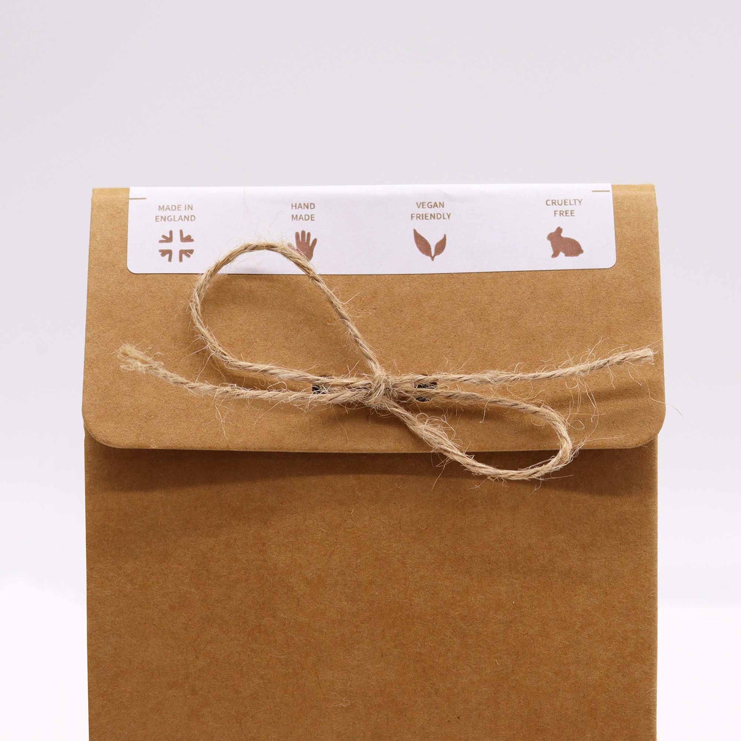 Brown packaging and brown string to seal the top, for bath bombs, bath. showing the made in England, hand made, vegan freindly and cruelty free logos