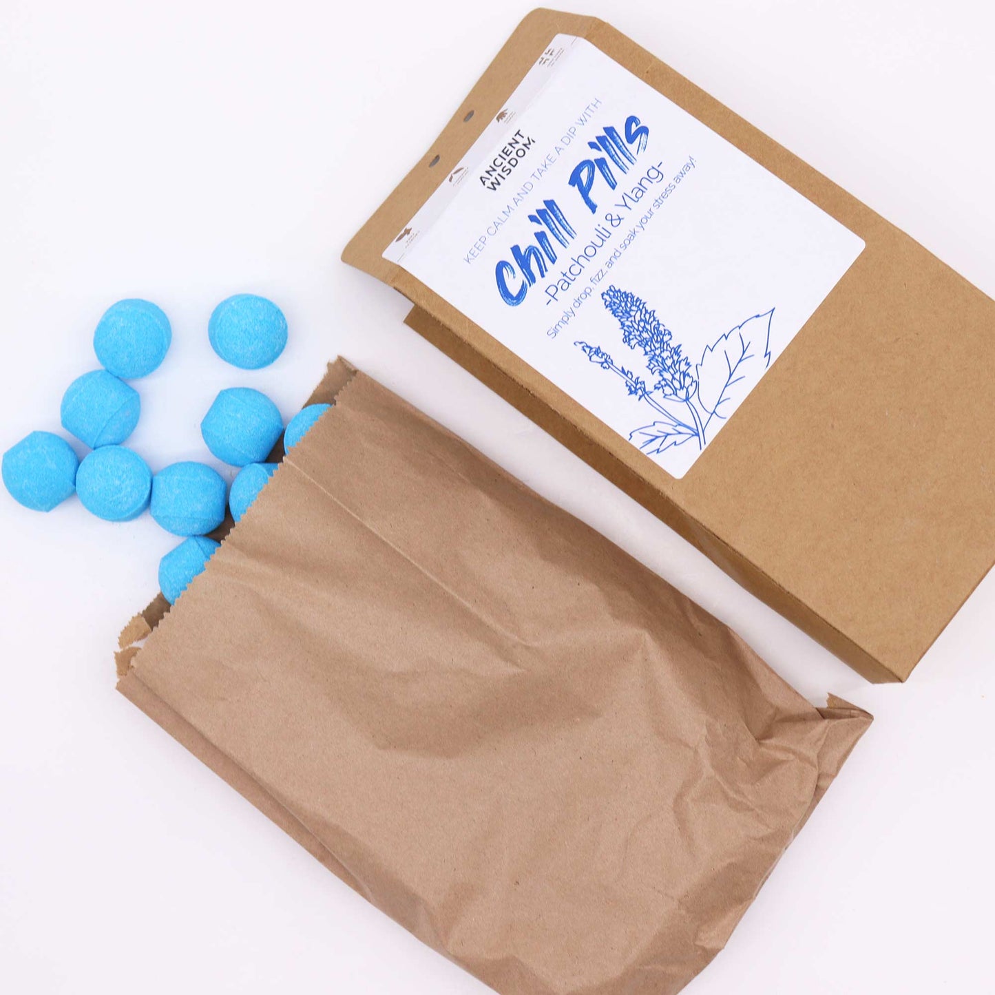 Image of loose bath bombs next to eco freindly brown packaging, labeled chill pills