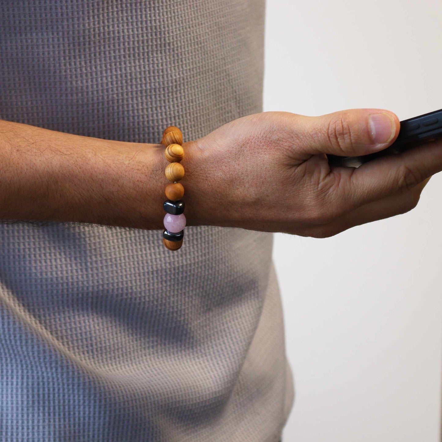 Rose Quartz gemstone. Handmade cedarwood and gemstone unisex bracelet with 7cm diameter, featuring natural wooden beads and vibrant gemstones, eco-friendly and stylish. Image of bracelet worn on right wrist