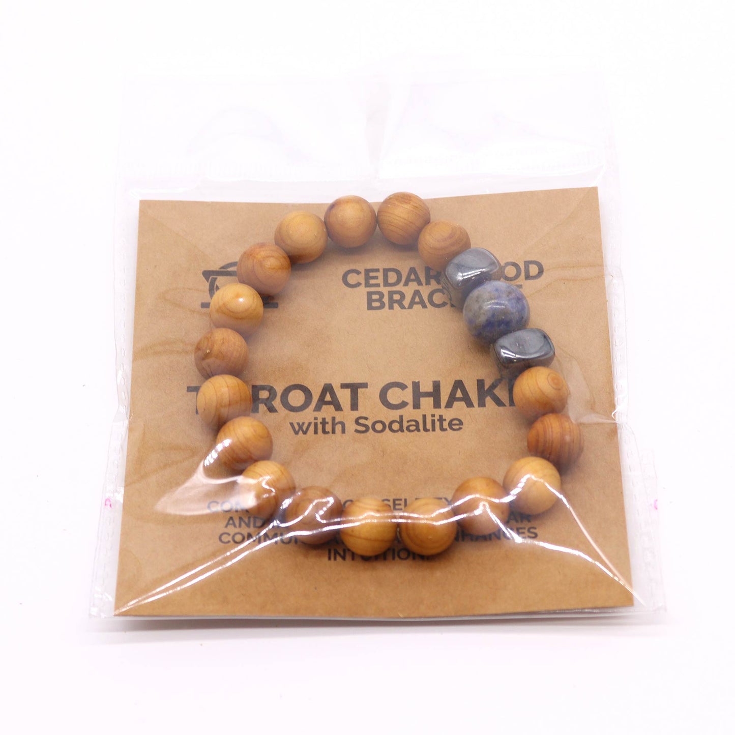 Handcrafted cedarwood throat chakra bangle with Sodalite gemstones. Eco-friendly unisex jewelry for spiritual balance. Shop now! Image of bracelet on white background inside packaging