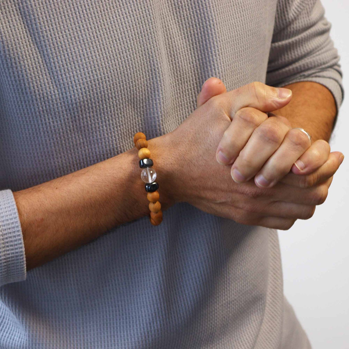 Handcrafted unisex cedarwood and gemstone bracelet with 7cm diameter, featuring natural wooden beads and vibrant gemstones, perfect for eco-friendly fashion. Image shows Worn on a mans wrist