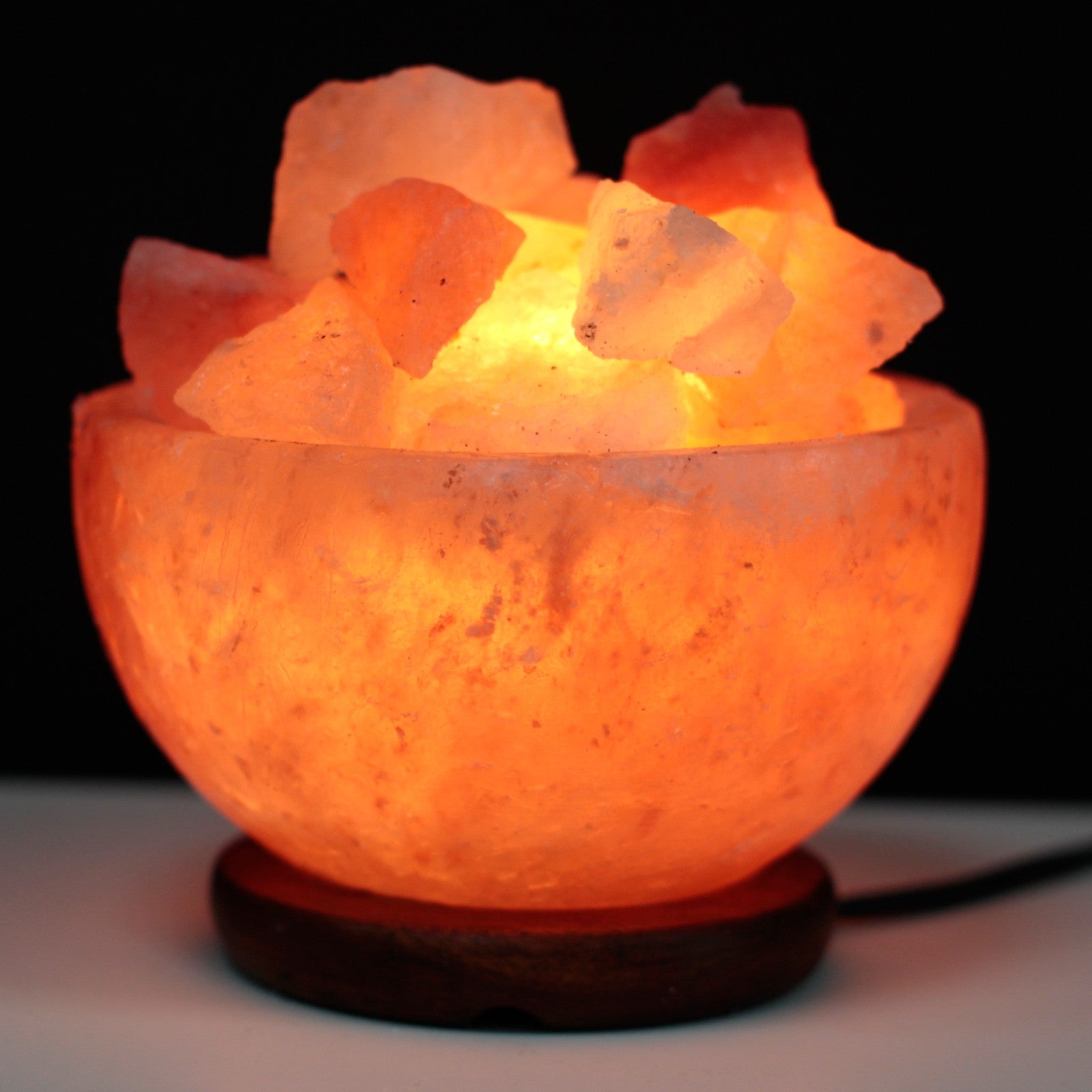 Image of salt lamp bowl and chunks brightly lit in the dark