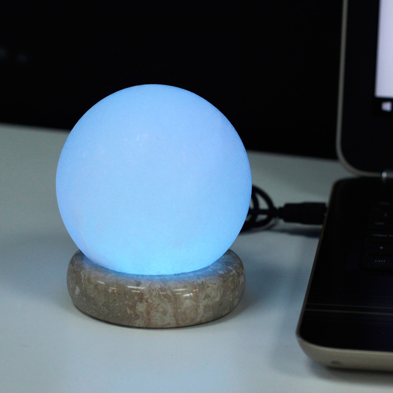  USB Ball White Salt Lamp glowing softly, emitting a tranquil aura in a room.