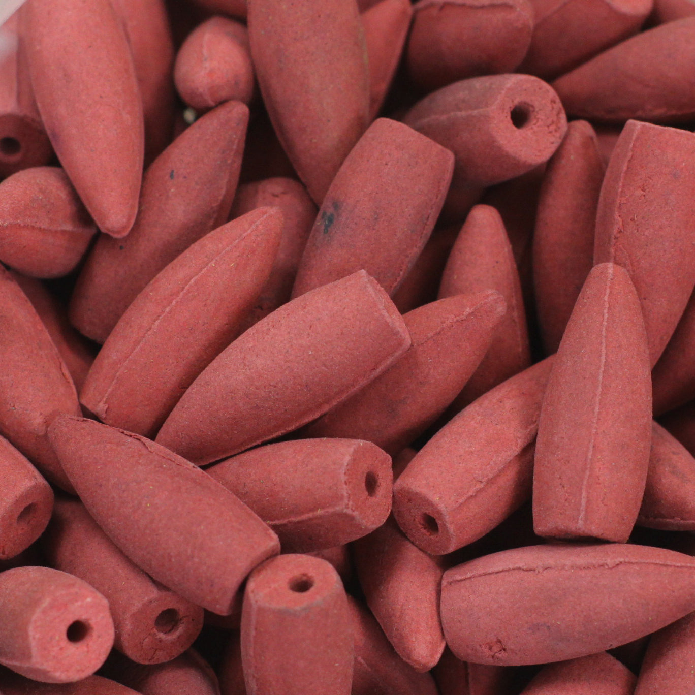  A stack of Dragon's Blood incense cones arranged on a white surface. Close up image of cones