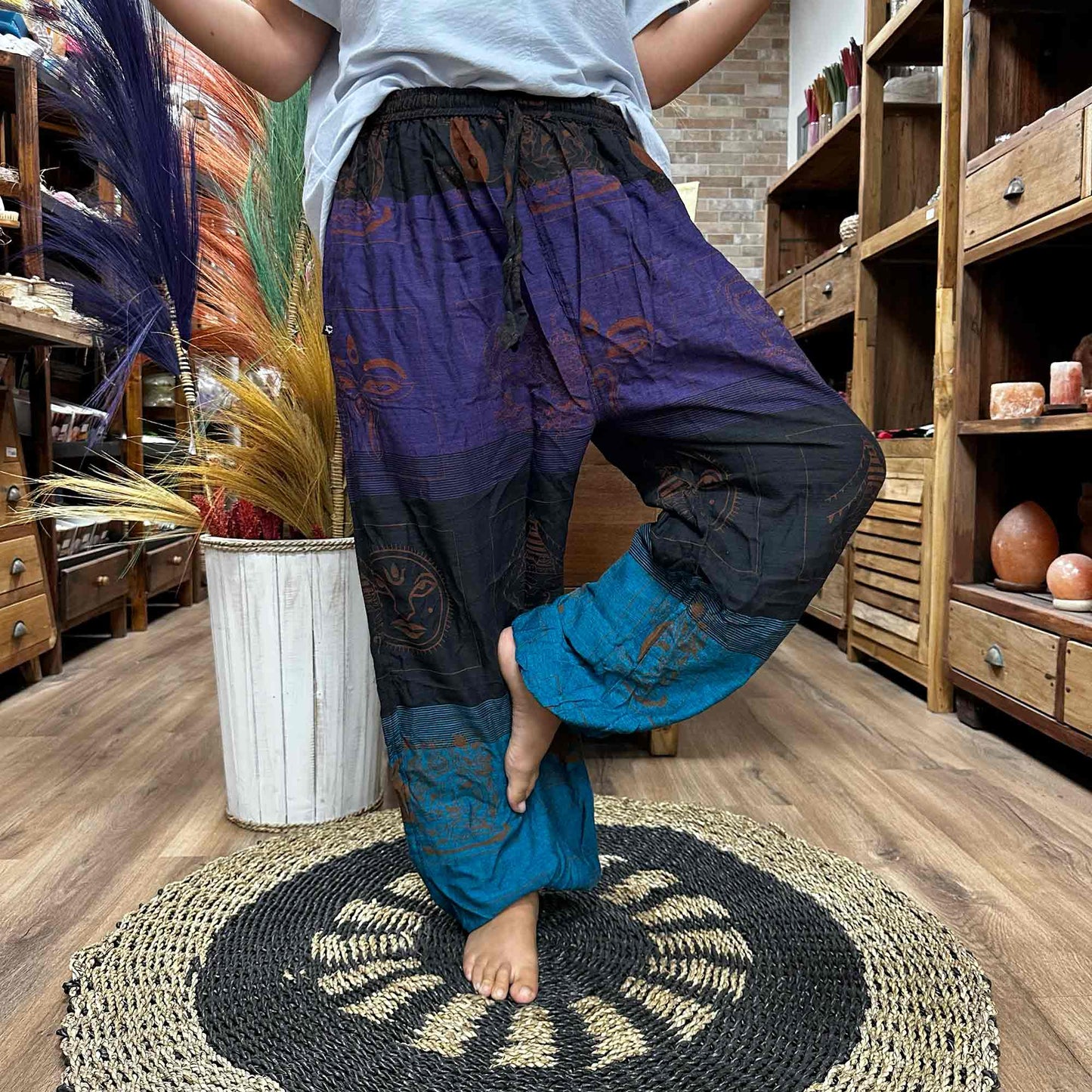 Person balancing on leg wearing High Cross Yoga & Festival Pants, Himalayan print on purple